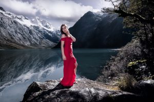 Graceful Lake - the girl in the red dress surronded by mountains - Milford Sound, New Zealand 2018
